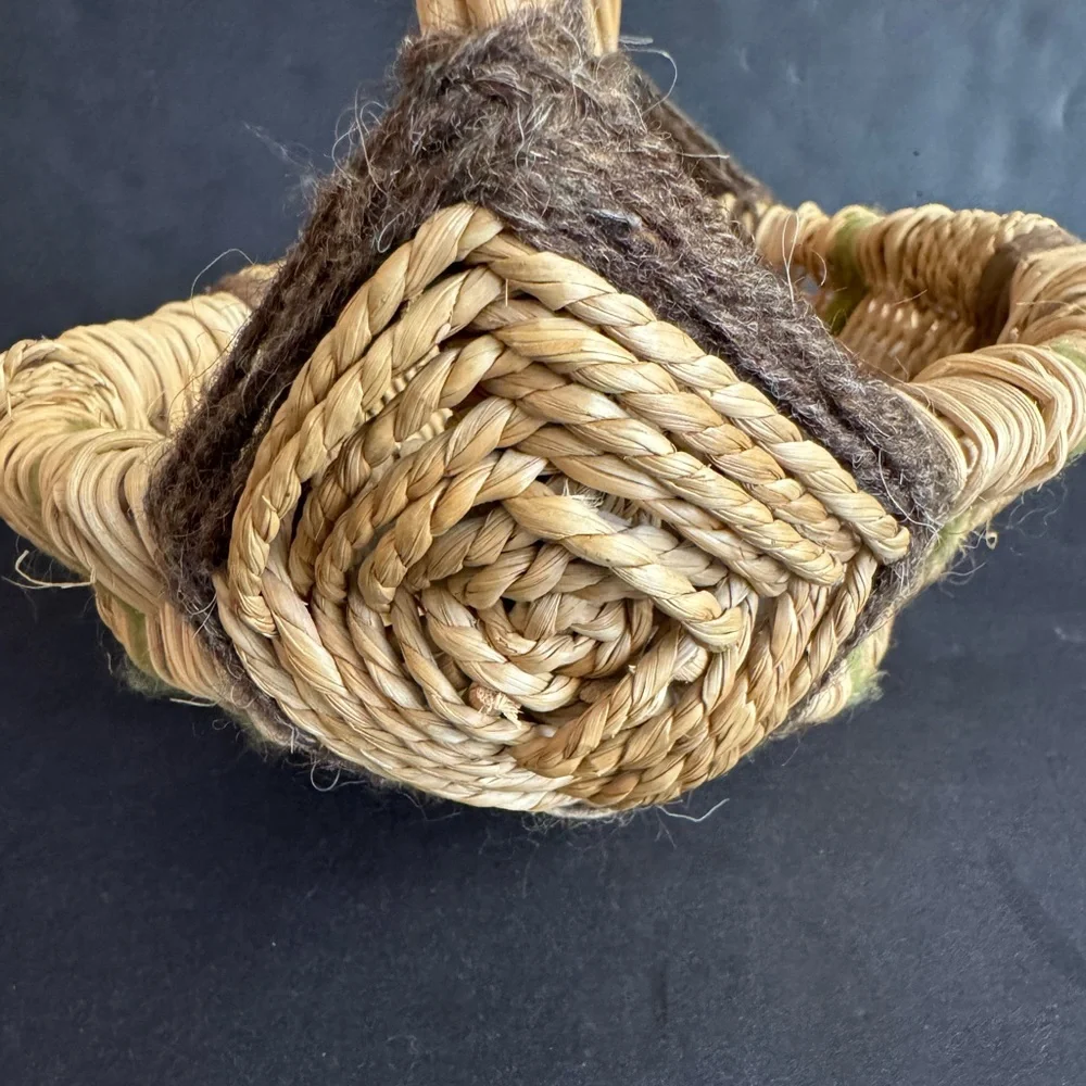 Vintage handwoven basket with brown and green yarn details and eye of God.